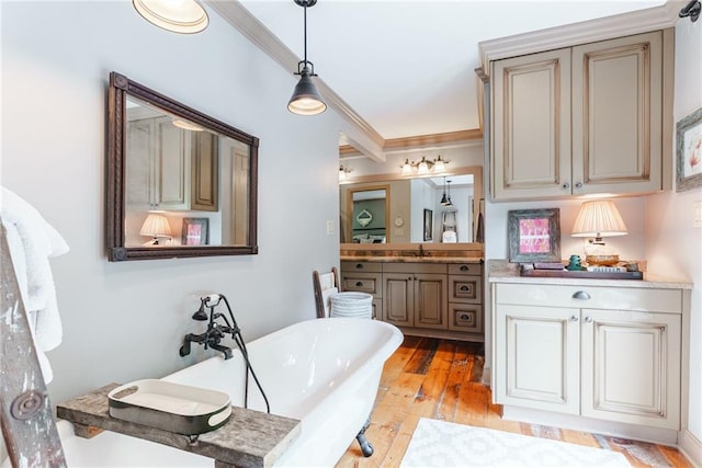 bathroom featuring hardwood / wood-style flooring, a bathtub, vanity, and crown molding