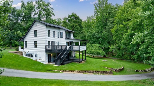 view of side of property with a wooden deck and a lawn