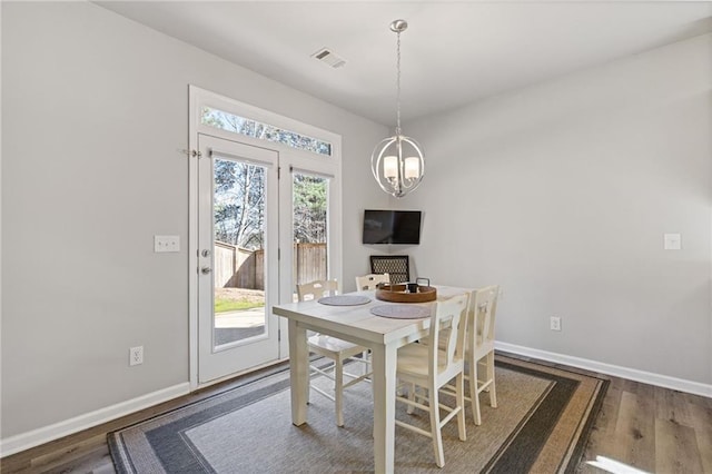 dining area with wood finished floors, visible vents, and baseboards