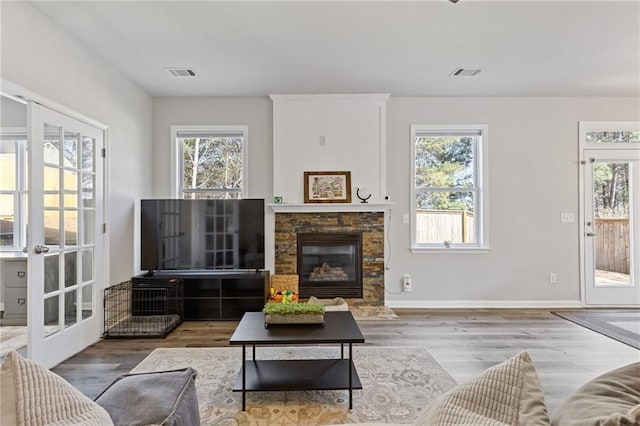 living room with plenty of natural light, wood finished floors, and visible vents