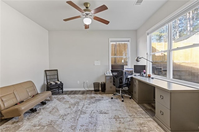 office featuring ceiling fan, visible vents, baseboards, and wood finished floors