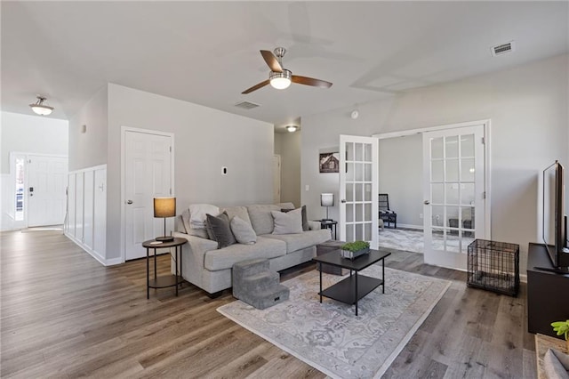 living area with french doors, visible vents, wood finished floors, and a ceiling fan