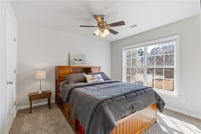 bedroom with visible vents, light carpet, baseboards, and a ceiling fan