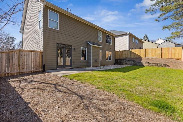 back of house featuring a patio, a yard, and a fenced backyard