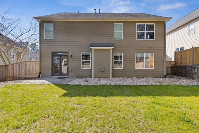 back of house featuring a yard, a fenced backyard, and french doors