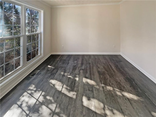 spare room featuring ornamental molding, wood finished floors, visible vents, and baseboards