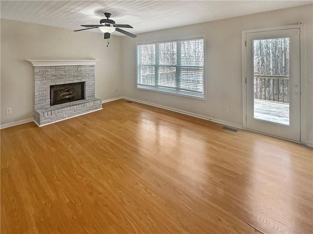 unfurnished living room featuring a fireplace, visible vents, light wood-style flooring, a ceiling fan, and baseboards