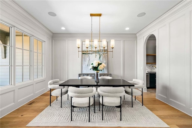 605 Claxton Ln, Milton, GA 30004 - dining area featuring a decorative wall, arched walkways, a chandelier, light wood finished floors, and ornamental molding