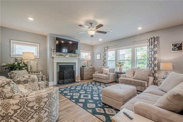 3715 Bridges Ct, Cumming, GA 30040 - living area with healthy amount of natural light, a ceiling fan, wood finished floors, a fireplace, and recessed lighting