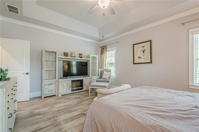 3715 Bridges Ct, Cumming, GA 30040 - bedroom featuring a tray ceiling, multiple windows, light wood-type flooring, and baseboards
