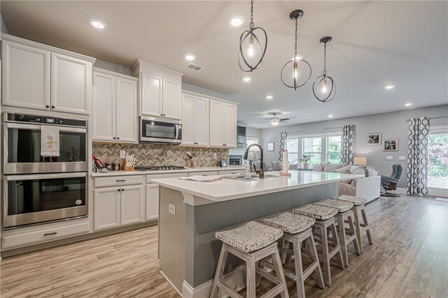 3715 Bridges Ct, Cumming, GA 30040 - kitchen with appliances with stainless steel finishes, a sink, open floor plan, recessed lighting, and plenty of natural light
