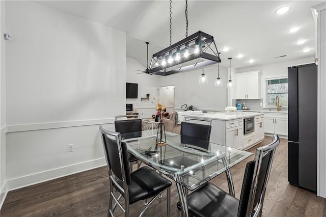 dining space with baseboards, a fireplace, recessed lighting, dark wood-type flooring, and vaulted ceiling