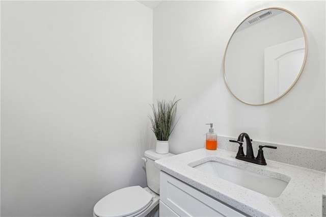 bathroom featuring vanity, toilet, and visible vents