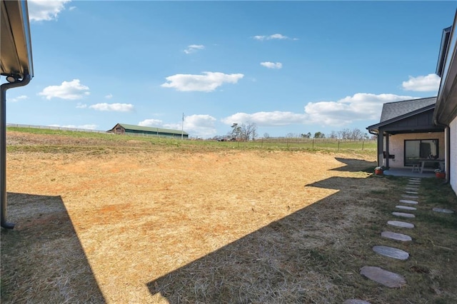 view of yard with a rural view and fence