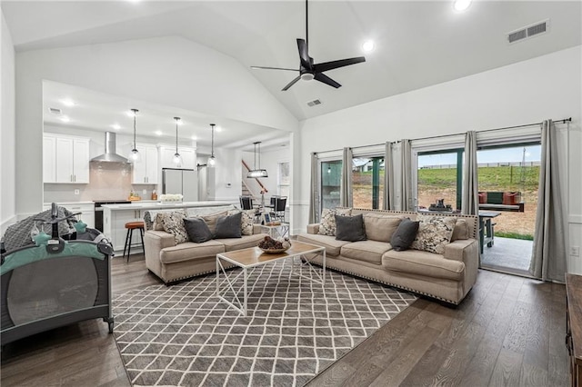 living room featuring ceiling fan, visible vents, high vaulted ceiling, and dark wood-style floors