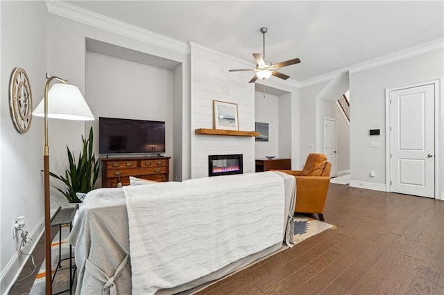 living room featuring crown molding, a fireplace, dark hardwood / wood-style floors, and ceiling fan