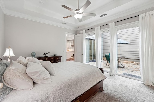 bedroom with crown molding, a tray ceiling, carpet, and access to outside
