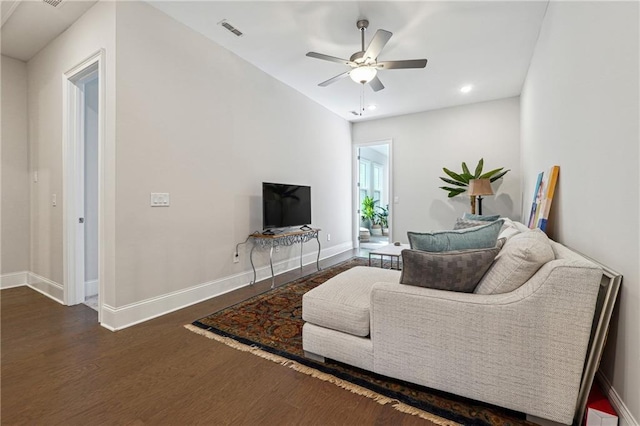 living room featuring ceiling fan and dark hardwood / wood-style flooring