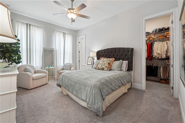 carpeted bedroom with a spacious closet, ceiling fan, and a closet