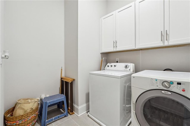 laundry room featuring cabinets, light tile patterned flooring, and separate washer and dryer