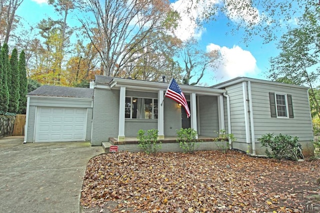 view of front of property featuring driveway, brick siding, and an attached garage