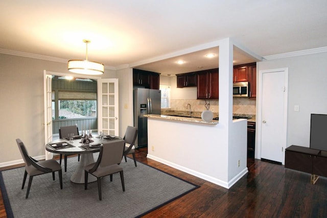 dining room with dark wood-style floors, a healthy amount of sunlight, and ornamental molding