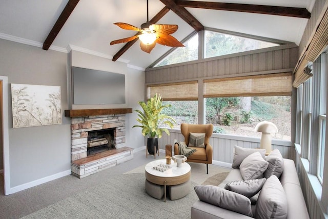 living room with baseboards, lofted ceiling with beams, ceiling fan, a stone fireplace, and carpet floors