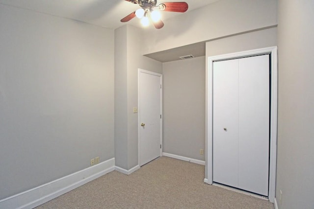 unfurnished bedroom featuring light carpet, a ceiling fan, visible vents, baseboards, and a closet