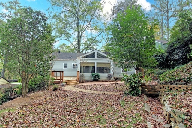 rear view of house with a sunroom and a wooden deck