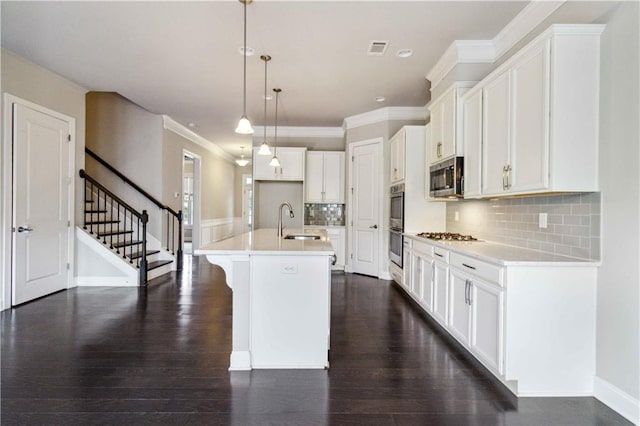kitchen with a sink, visible vents, light countertops, appliances with stainless steel finishes, and an island with sink