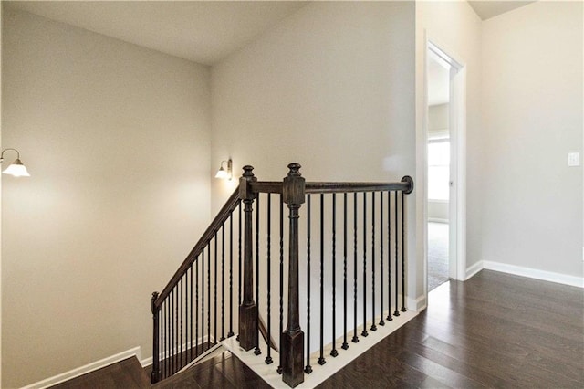 stairway featuring wood finished floors and baseboards