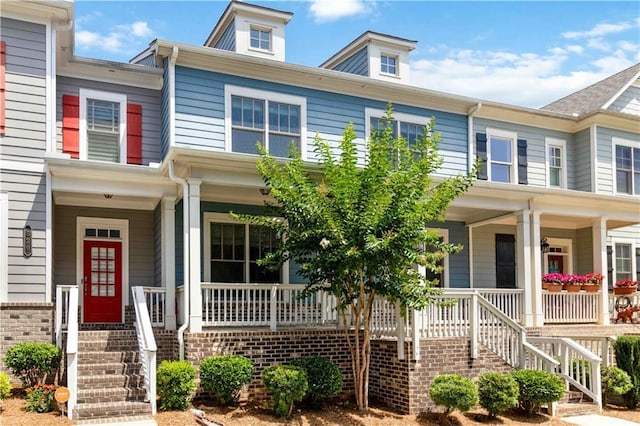view of property with stairway and covered porch