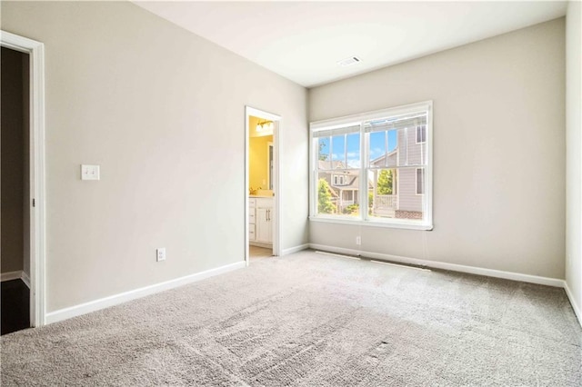 spare room featuring baseboards, visible vents, and light colored carpet