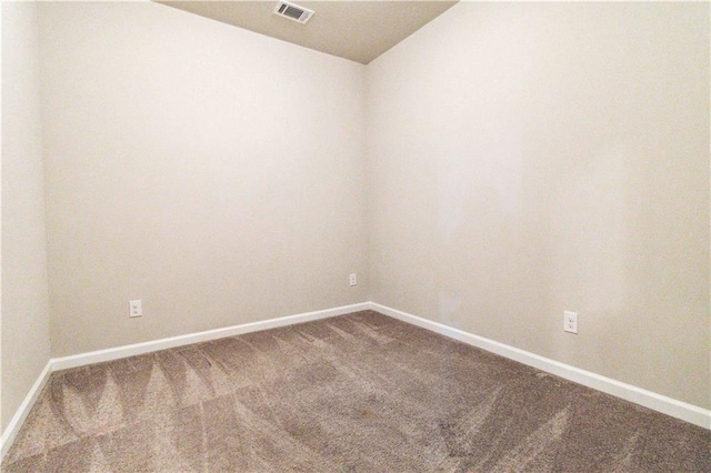 unfurnished room featuring baseboards, visible vents, dark carpet, and lofted ceiling