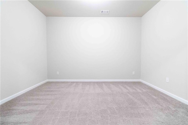 spare room featuring baseboards, visible vents, and carpet flooring