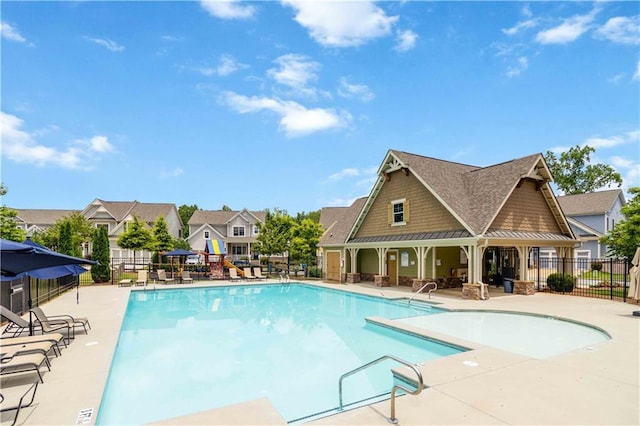 pool featuring a residential view, a patio, and fence