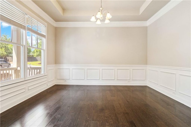 empty room with dark wood-style flooring, a chandelier, and a tray ceiling