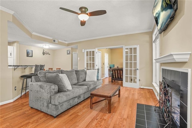 539 Mcgill Park Ave NE, Atlanta, GA 30312 - living area featuring french doors, ceiling fan, ornamental molding, a textured ceiling, and light wood-style floors