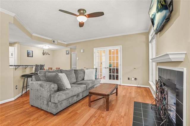 539 Mcgill Park Ave NE, Atlanta, GA 30312 - living room featuring crown molding, a ceiling fan, a fireplace, french doors, and wood finished floors