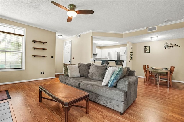 539 Mcgill Park Ave NE, Atlanta, GA 30312 - living area featuring a ceiling fan, a textured ceiling, light wood-style floors, ornamental molding, and baseboards