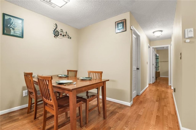 539 Mcgill Park Ave NE, Atlanta, GA 30312 - dining space featuring a textured ceiling, light wood-style floors, and baseboards