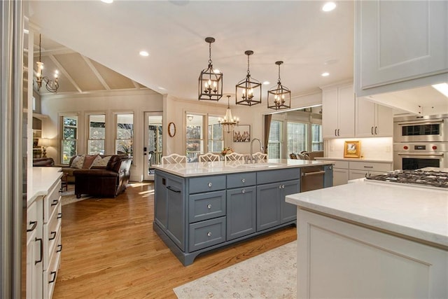 kitchen featuring pendant lighting, a kitchen island, white cabinetry, and light hardwood / wood-style floors