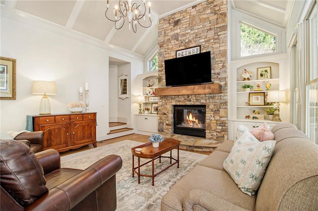 living room featuring a fireplace, built in shelves, an inviting chandelier, and high vaulted ceiling