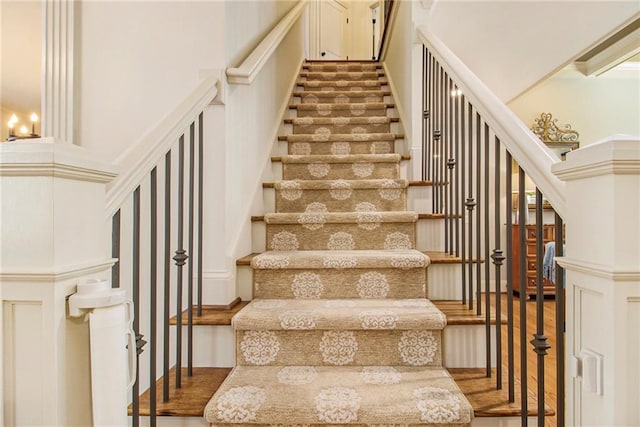 hallway with light hardwood / wood-style flooring, ornamental molding, and a notable chandelier