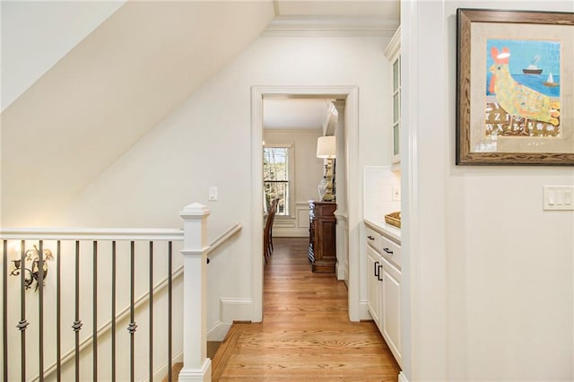 staircase with hardwood / wood-style flooring, crown molding, and a notable chandelier