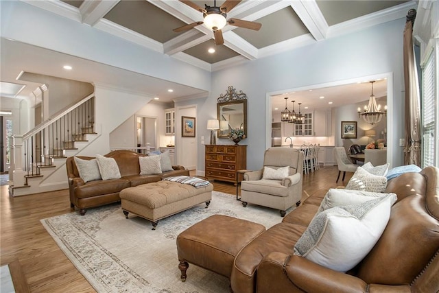 living room with light wood-type flooring, a wealth of natural light, coffered ceiling, ceiling fan with notable chandelier, and beam ceiling