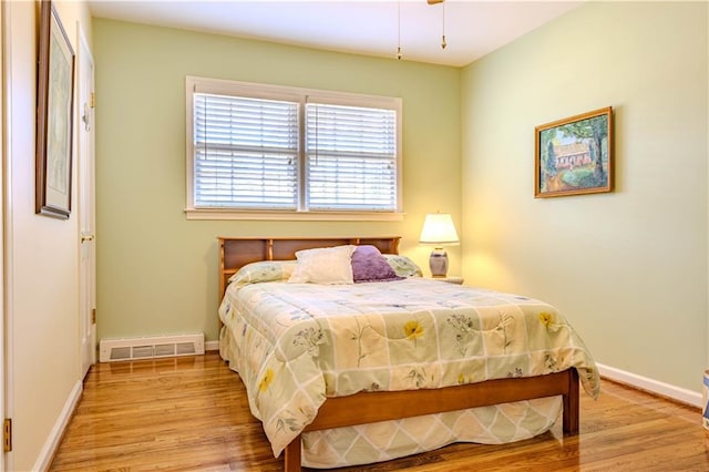 bedroom featuring light wood-type flooring, visible vents, and baseboards