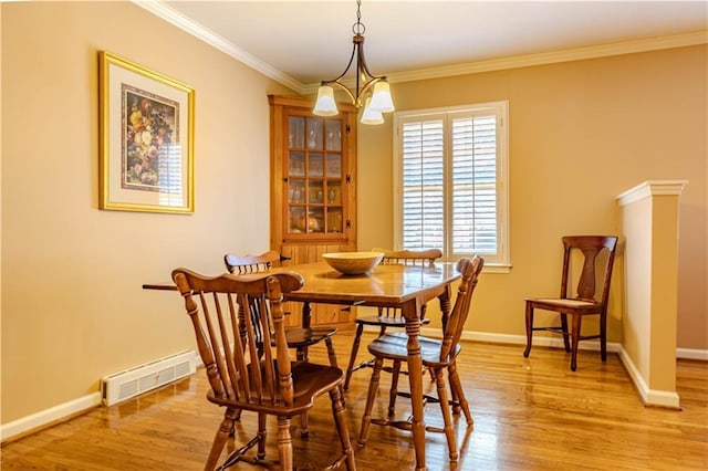 dining area with baseboards, light wood finished floors, visible vents, and crown molding