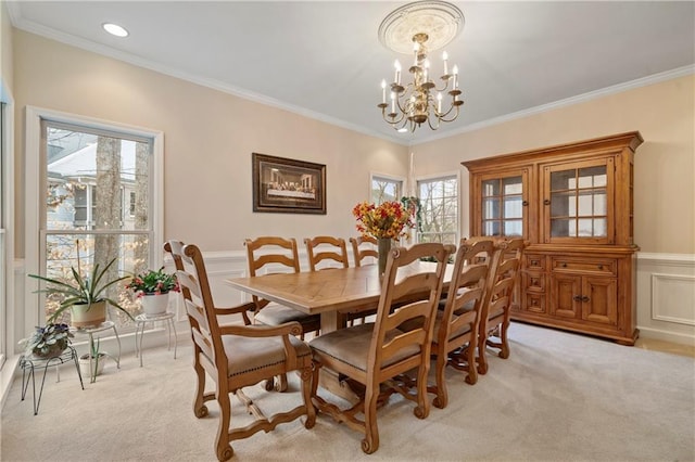 2287 Lake Ridge Ter, Lawrenceville, GA 30043 - dining area featuring light carpet, a chandelier, healthy amount of natural light, a wainscoted wall, and crown molding
