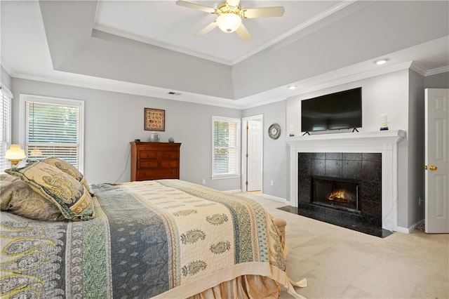 2287 Lake Ridge Ter, Lawrenceville, GA 30043 - bedroom featuring a tiled fireplace, carpet, multiple windows, ornamental molding, and a tray ceiling